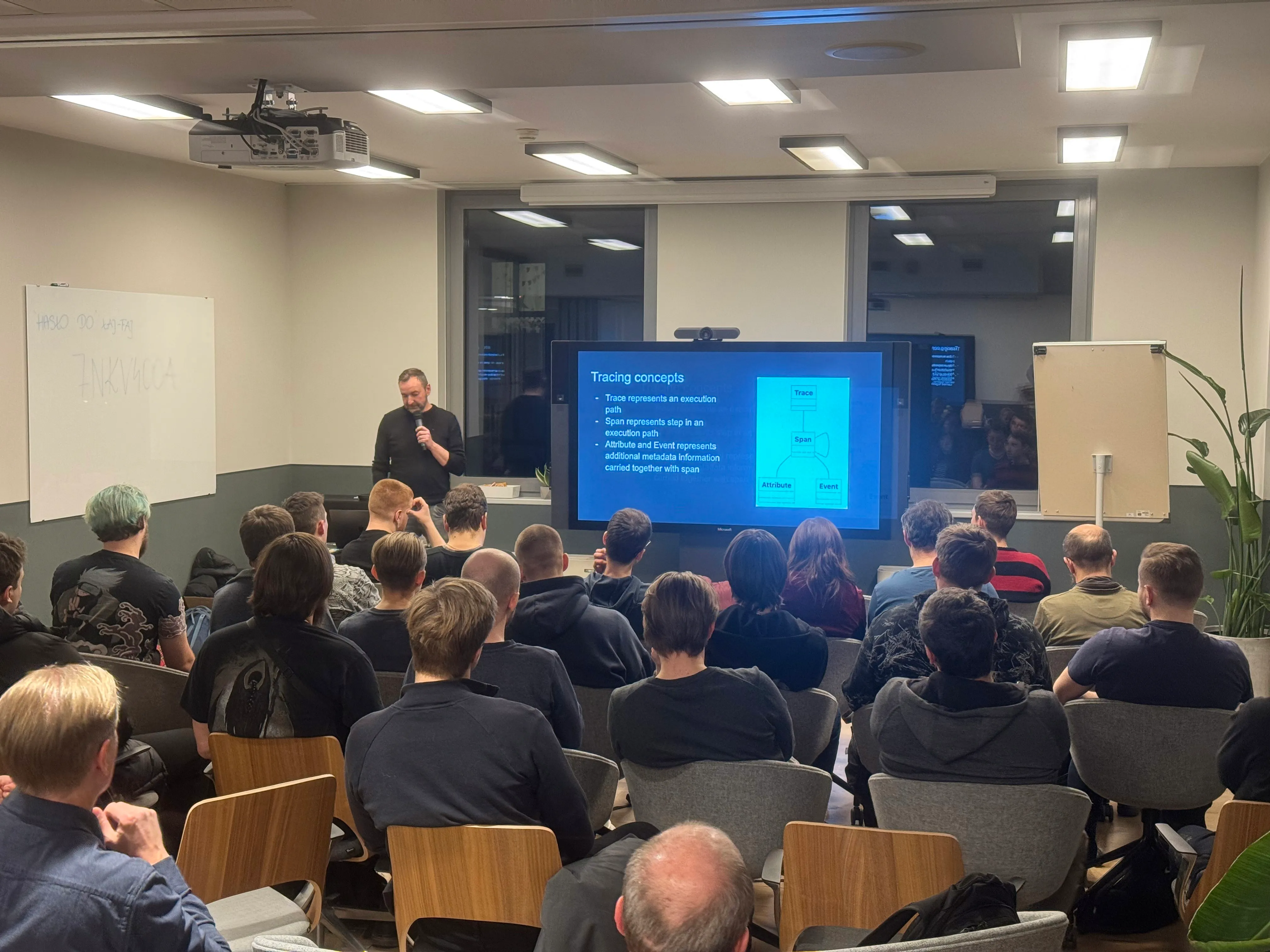 Speaker presenting tracing concepts to an audience with slides on a large screen