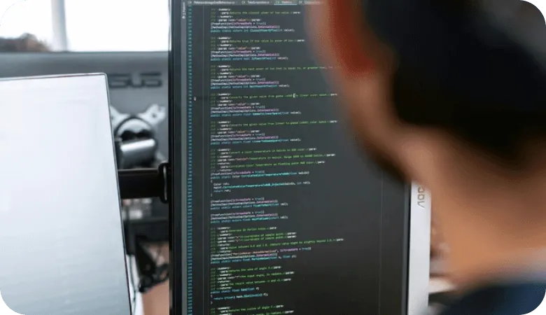Developer viewing Python code on a computer monitor in a workspace